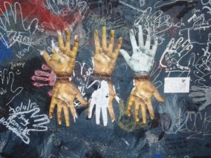 This mixed media graffiti at the East Side Gallery prompts viewers to trace outlines of their own hands. 